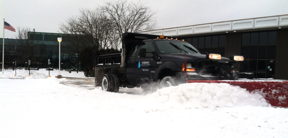 A truck efficiently plowing a paved area